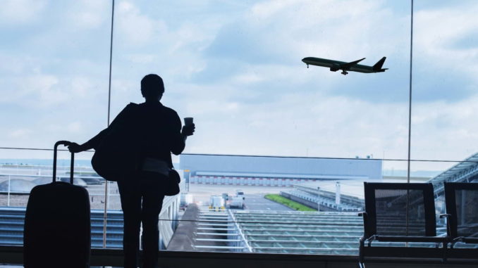 imagem de turista no aeroporto com passagem de avião na mão